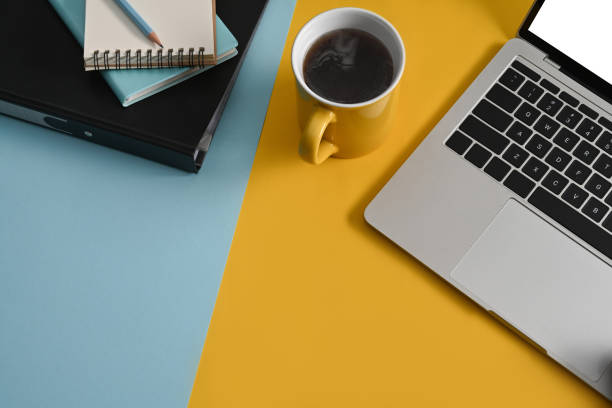 istock Stylish workplace with computer laptop, coffee cup and notepad on colorful background. Top view. 1382812393