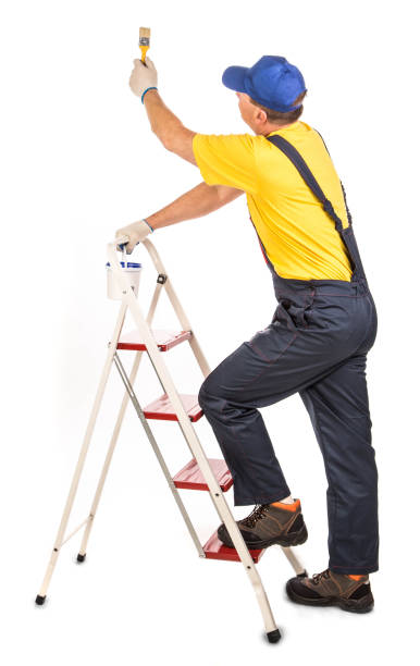 istock A painter with a brush on the stairs. 1382813940