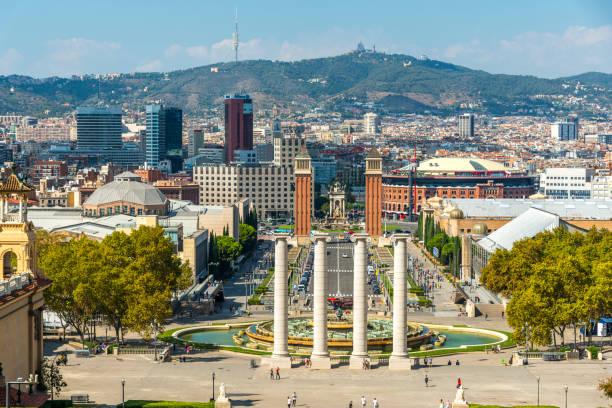 High angle view of Espana square under sunny day in Barcelona, Spain. There is Magic Fountain in frame. Horizontal composition. The Magic Fountain of Montjuic is a fountain located at the head of Avinguda Maria Cristina in the Montjuic neighbourhood of Barcelona, Catalonia, Spain. The fountain is situated below the Palau Nacional on the Montjuic mountain and near the Placa d'Espanya and Poble Espanyol de Barcelona.