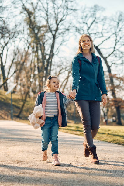 istock Happy mother and daughter holding hands while walking in nature. 1382820153