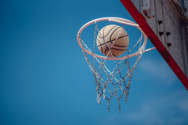 istock Basketball Shot Falling Through the Net with the Blue Sky background. 1382821872