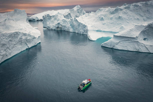 istock SMALL SHIP SAILING BETWEEN BIG ICEBERGS FROM AERIAL VIEW 1382822419