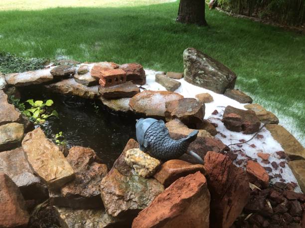 istock Small backyard pond with fresh snow on the green grass 1382827496