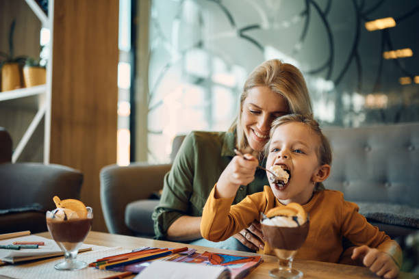 kuvapankkikuvat ja rojaltivapaat kuvat aiheesta pieni tyttö nauttii suklaamoussen syömisestä ollessaan äitinsä kanssa kotona. - mousse dessert
