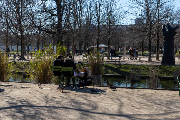 personen, die im jardin des tuileries in der nähe des louvre sitzen - people winter urban scene chair stock-fotos und bilder