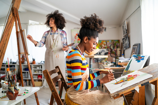 Afro female fine artists drawing together in a studio