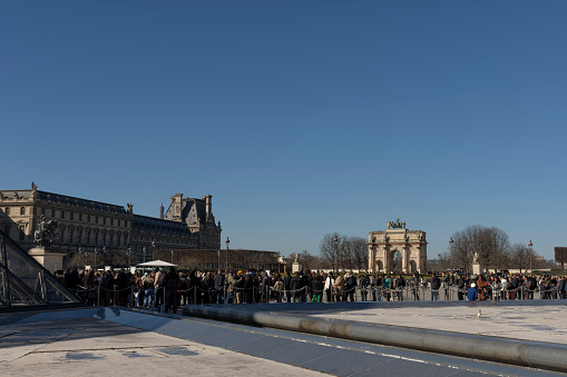 The Louvre in Paris France, This is the famous building close to the River Seine and includes both the Venus de Milo and the Mona Lisa.  In the foreground are the queues for entry.