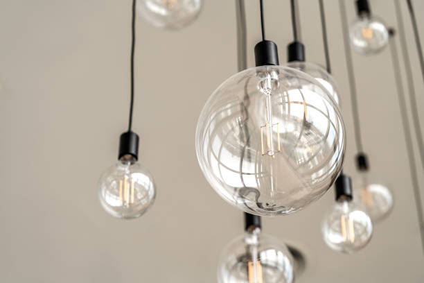istock Modern interior light bulbs on the high white ceiling, round shape hanging light bulbs, blank space, worm eye view image 1382846962