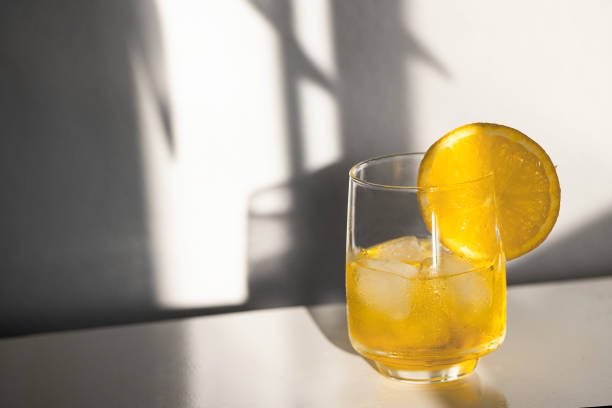istock Alcohol cocktail with ice cubes on white background with hard light and shadow. Summer time and vacation concept. 1382853377