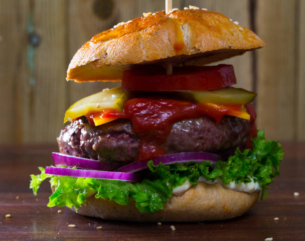 istock grilled hamburger with beef, tomato, cheese, cucumber and ketchup 1382859064