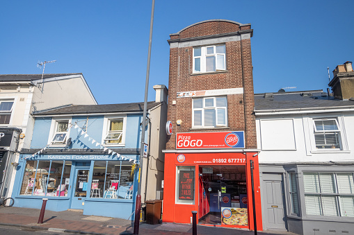 Pizza GoGo on Camden Road at Royal Tunbridge Wells in Kent, England, with an upholstery shop next door.