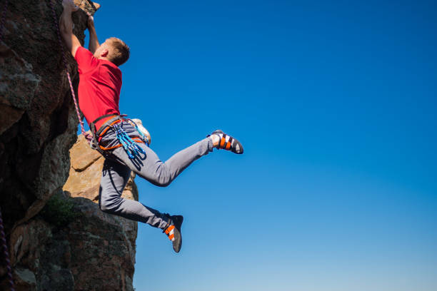 istock Young male climber hanging by a cliff 1382860944