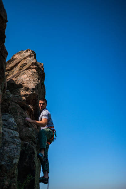 istock Young handsome sportsman getting ready to climb a rock cliff 1382860965