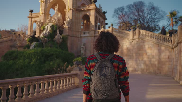 Rear view of unrecognizable male tourist exploring Parc de la Ciutadella