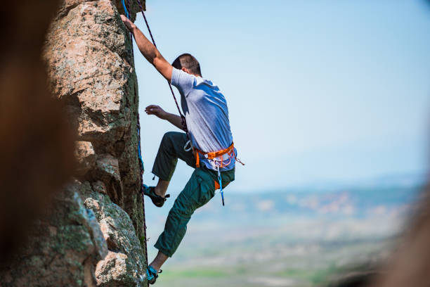 istock Rock climber battles his way up 1382864216