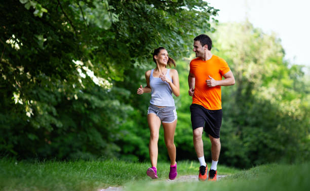 Portrait of happy fit people running together ourdoors. Couple sport healthy lifetsyle concept stock photo