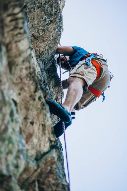 istock Strong male climber hanging by a cliff 1382868862