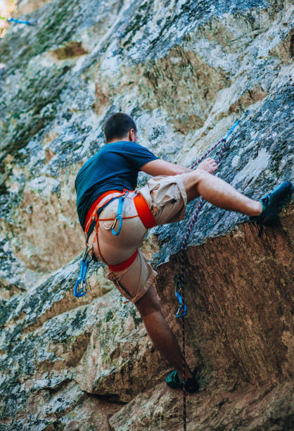 istock Strong man climbs the rock 1382868864