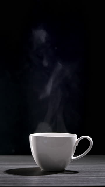 Vertical shot of hot coffee cup on black background,Close-up