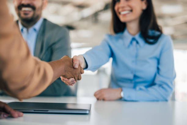 istock Smiling female shaking hands with another female, at the office. 1382905656