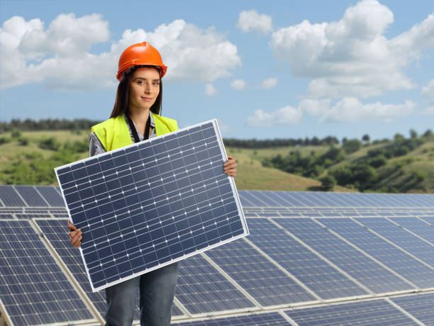 jeune ingénieure tenant un panneau solaire photovoltaïque sur une centrale solaire photovoltaïque - solar panel engineer solar power station women photos et images de collection