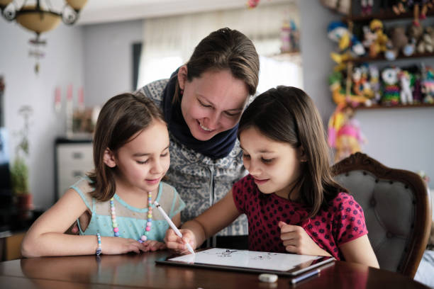 istock Mother And Daughters Painting Picture On Digital Tablet Using Digitized Pen At home 1382910673