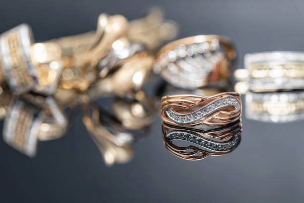 Elegant gold ring decorated with small precious stones on the background of a gold chain and bracelet