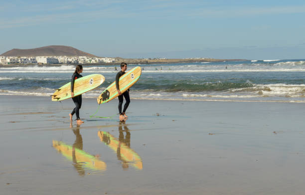 Practicing surf on Famara beach at Lanzarote in Canary islands, Spain stock photo