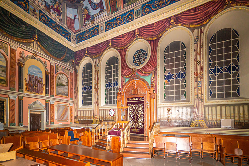 Lviv, Ukraine - March 02 2022: Bright shot of interior of historic Jewish Synagogue or with altar, arched windows and chandelier in Lviv