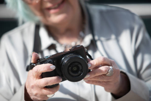 istock woman's hands holding a digital camera outdoors 1382919894
