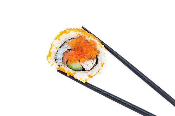 Japanese Sushi roll with black chopsticks, isolated on white background.