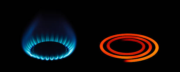 Gas and electric energy types A gas and electric cooker ring on full power stove stock pictures, royalty-free photos & images