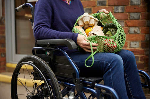 Close Up Of Woman In Wheelchair Holding Zero Waste Packaging Shopping In Sustainable Bag