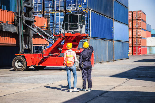 istock Worker man and Female engineer control loading containers box from cargo, caucasian industrial foreman worker in hard hat 1382954890