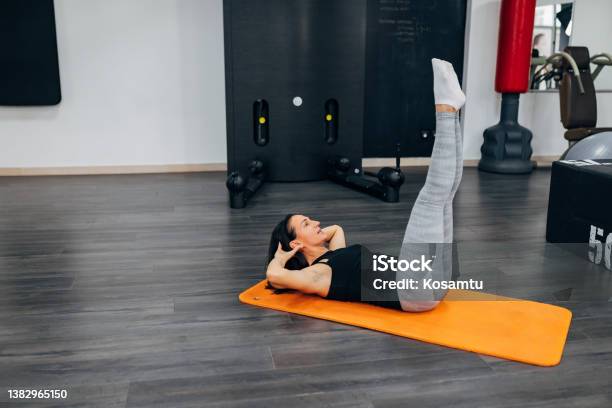 Lying On An Exercise Mat The Female Athlete Does Situps And Thus Tightens The Abdominal Muscles Stock Photo - Download Image Now
