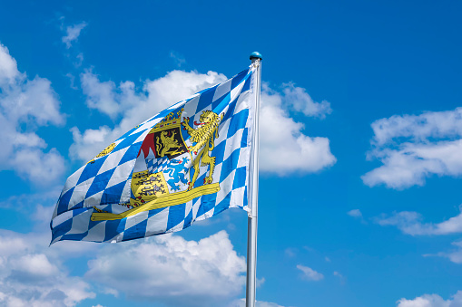 View of a Bavarian flag waving in the wind in front of a white-blue sky