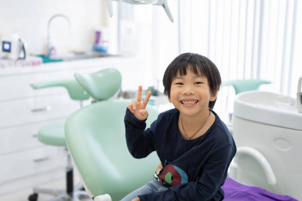 The Asian boy feel happy to sit on the dental chair in dental clinic The Asian boy feel happy to sit on the dental chair in dental clinic pediatric dentistry stock pictures, royalty-free photos & images