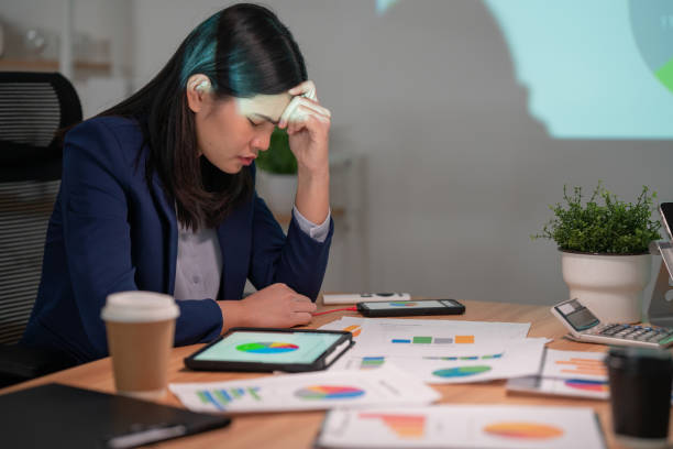 hard-working businesswomen sit stressed at the meeting table in the office. - defeat imagens e fotografias de stock