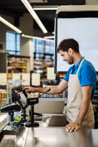 istock Employee in supermarket working at the checkout 1382995790