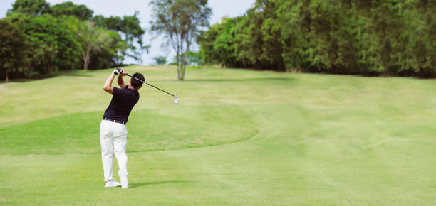istock Man playing golf on a golf course panorama banner background 1382996885