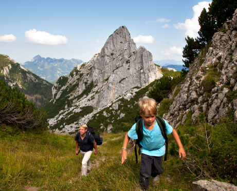 Father and son hiking on mountain path