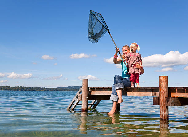mother and daughter fishing with net - mature woman having fish bildbanksfoton och bilder