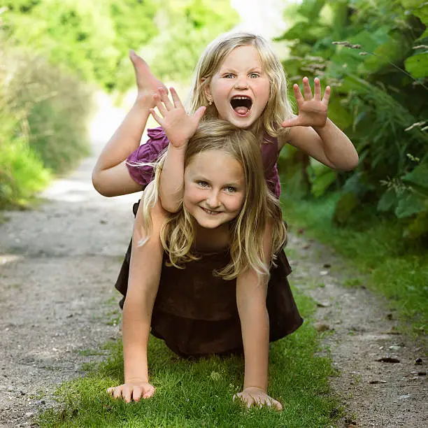 Photo of Girls playing together on dirt path