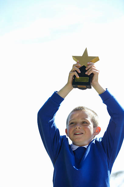 estudiante aclamando con trophy - winning achievement award little boys fotografías e imágenes de stock