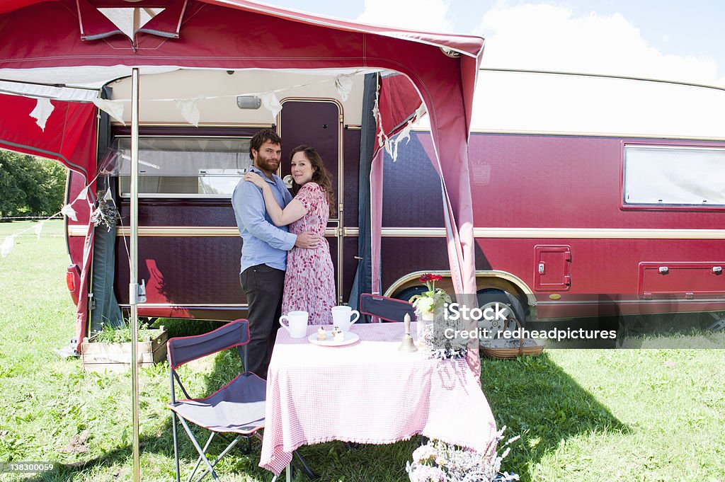 Couple hugging outside trailer  Camper Trailer Stock Photo