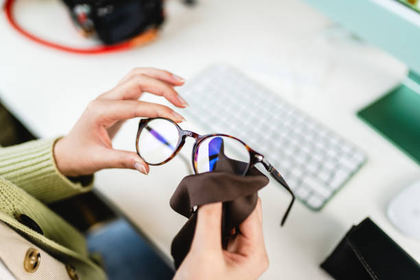 istock Unrecognizable female hand wiping glasses in office 1383000762