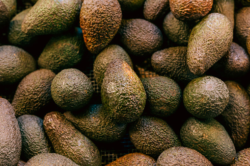 Color image depicting a collection of fresh ripe avocados for sale at an outdoor food market in London, UK. Overhead view of this delicious food, with room for copy space.