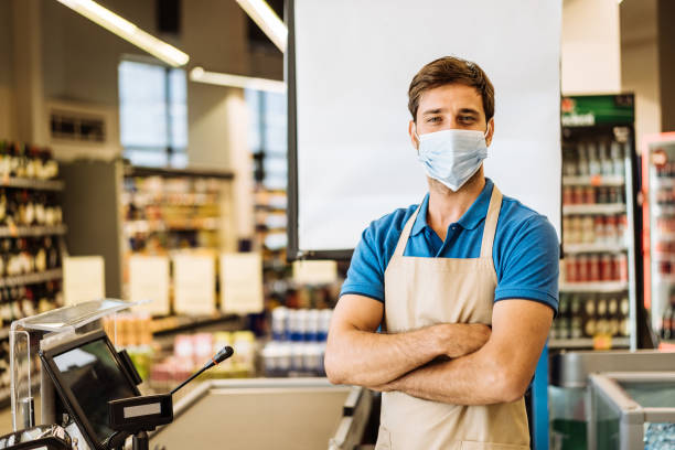 istock Employee in supermarket working at the checkout 1383002982