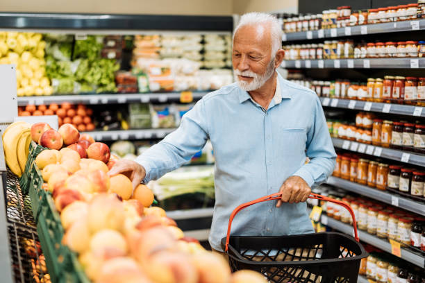 retired man buying groceries - fruits and vegetables - boodschappen stockfoto's en -beelden