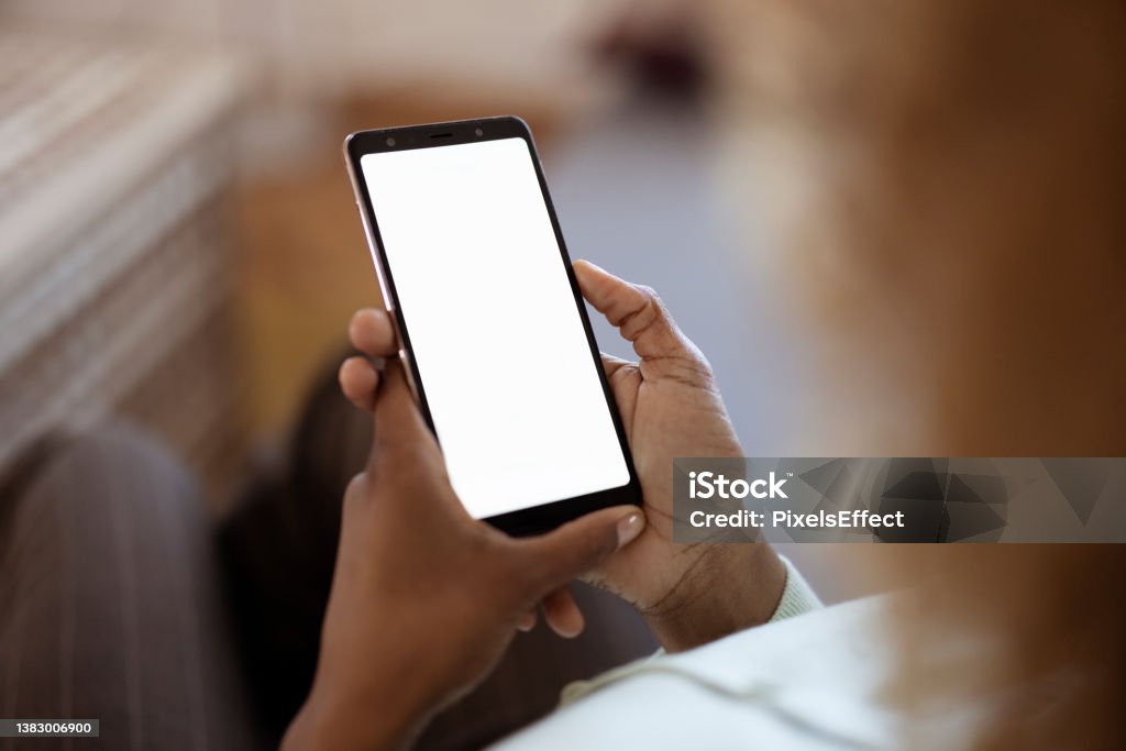 Mock-up Screen Smartphone Young Woman at Home Uses Mock-up Screen Smartphone. Point of View Shot. Template Stock Photo